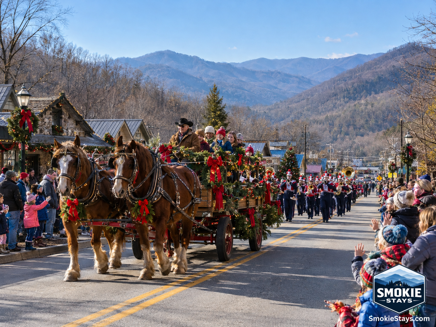 A horse-drawn wagon decorated with Christmas greenery and ribbons leads the Townsend Christmas Parade through the main corridor of Townsend, Tennessee, with families lining the sidewalks and bare Smoky Mountain ridgelines rising on both sides under a clea